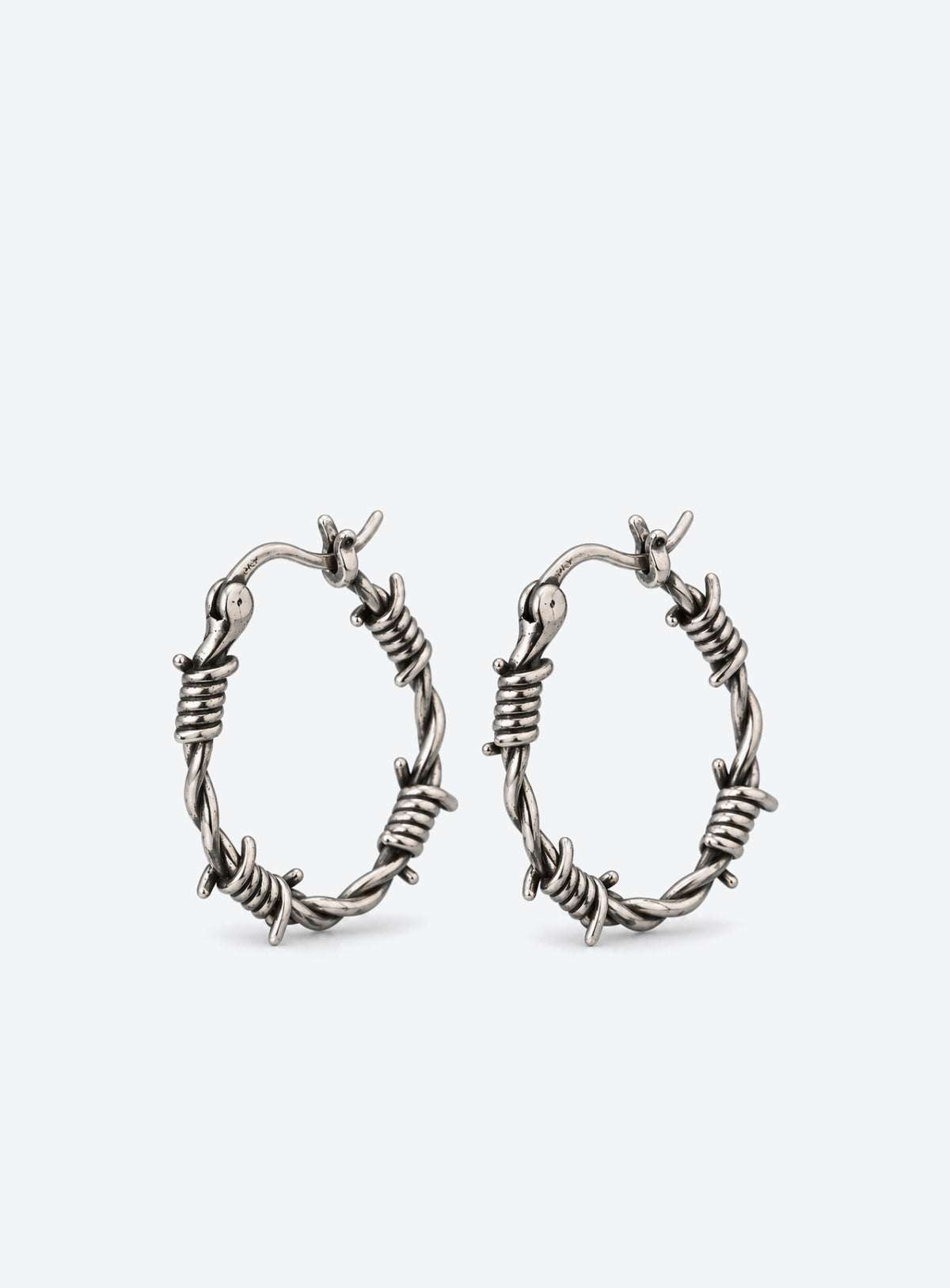 Silver hoop earrings on a teal surface