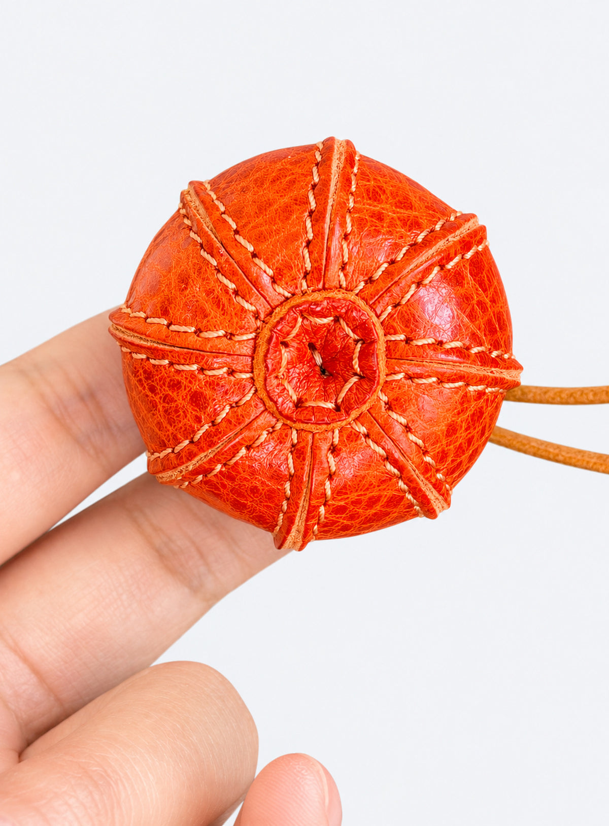 Pumpkin-shaped leather bag charm with stitched panels, a leaf accent, and a hanging loop (Pumpkin Orange)