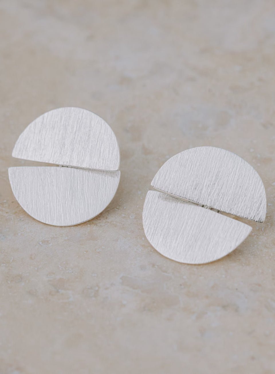Pair of silver earrings on a beige background (Silver)