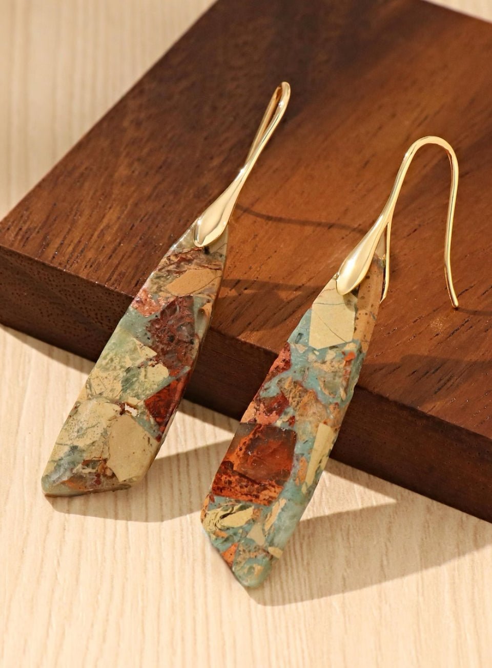 Pair of earrings with floral pattern on a wooden surface (Gold)