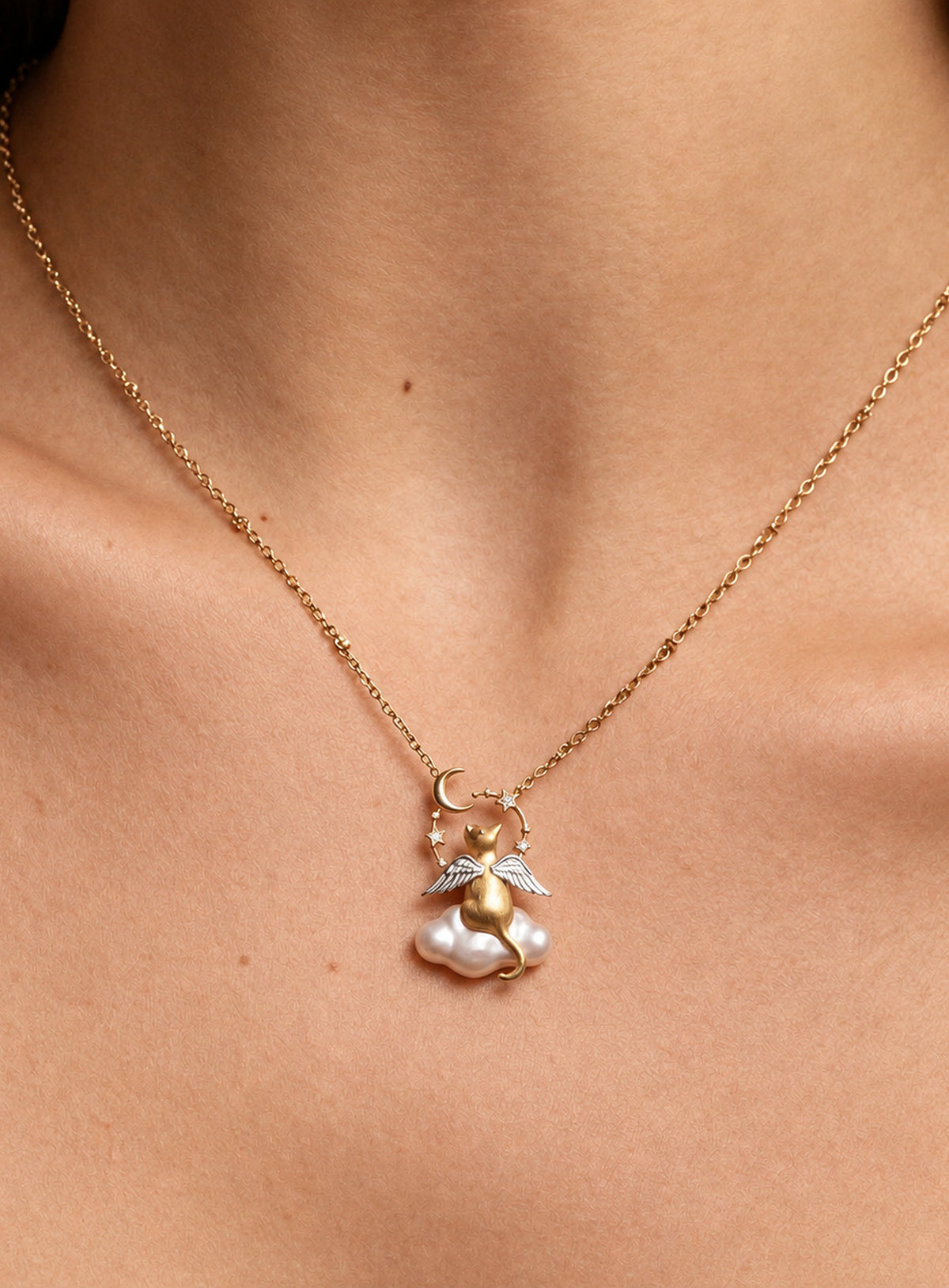 Necklace with a winged cat pendant sitting on a baroque-style pearl cloud with moon and star accents