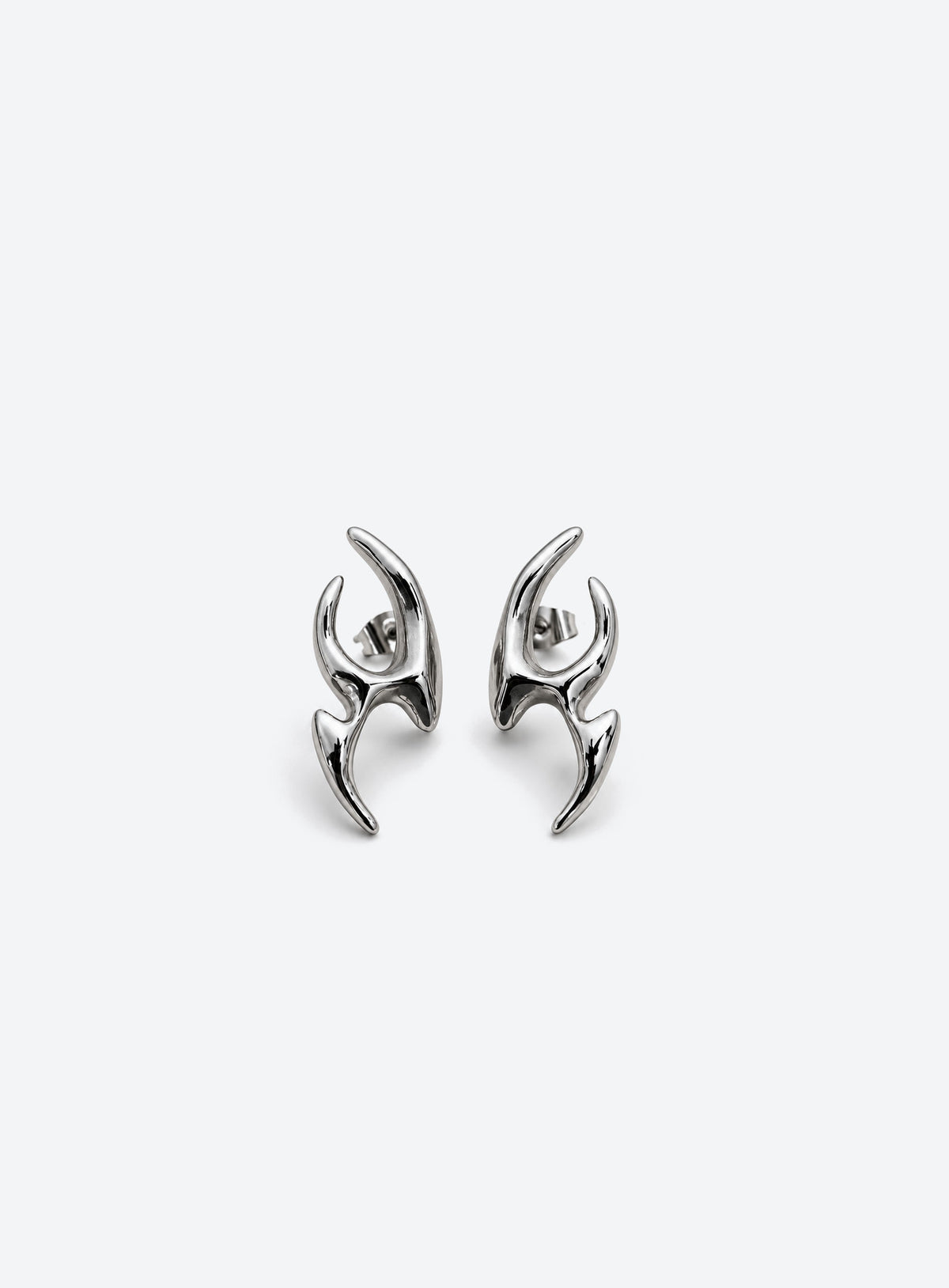 Pair of asymmetric stud earrings with curved points, open cutouts, and a polished silver appearance