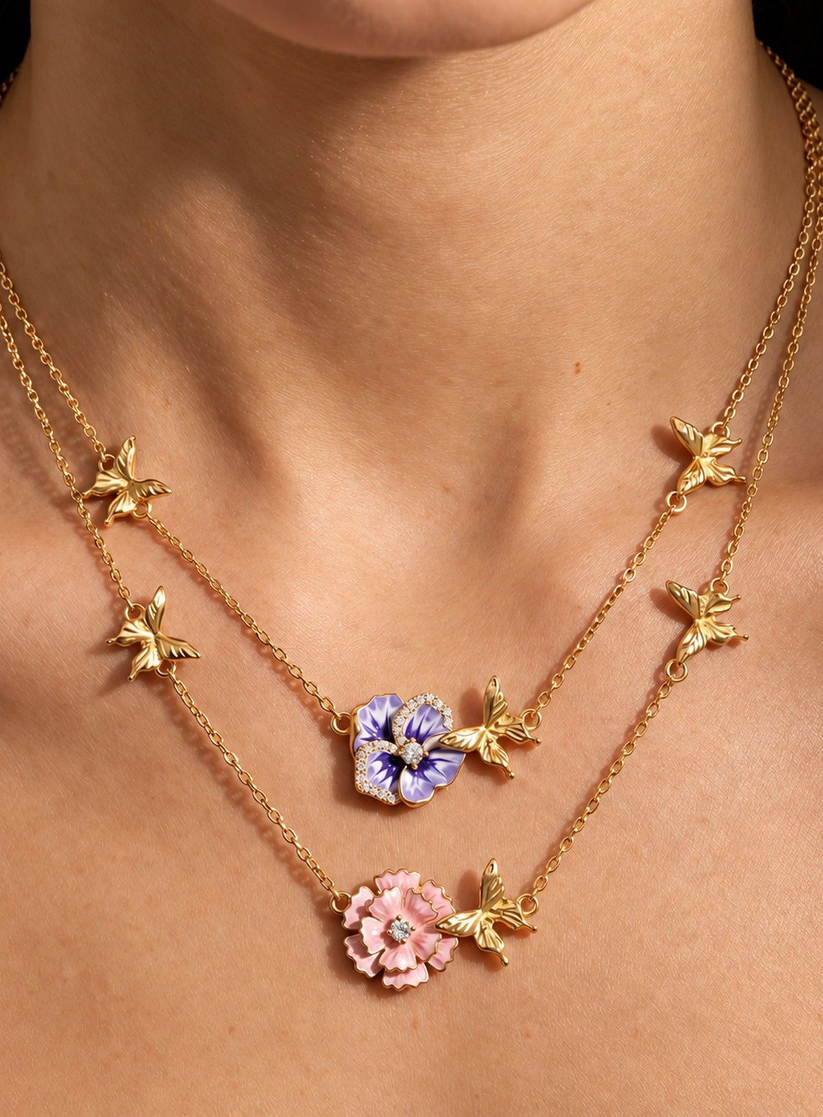 Birth flower necklace with an enamel flower centerpiece and small butterfly accents along the chain