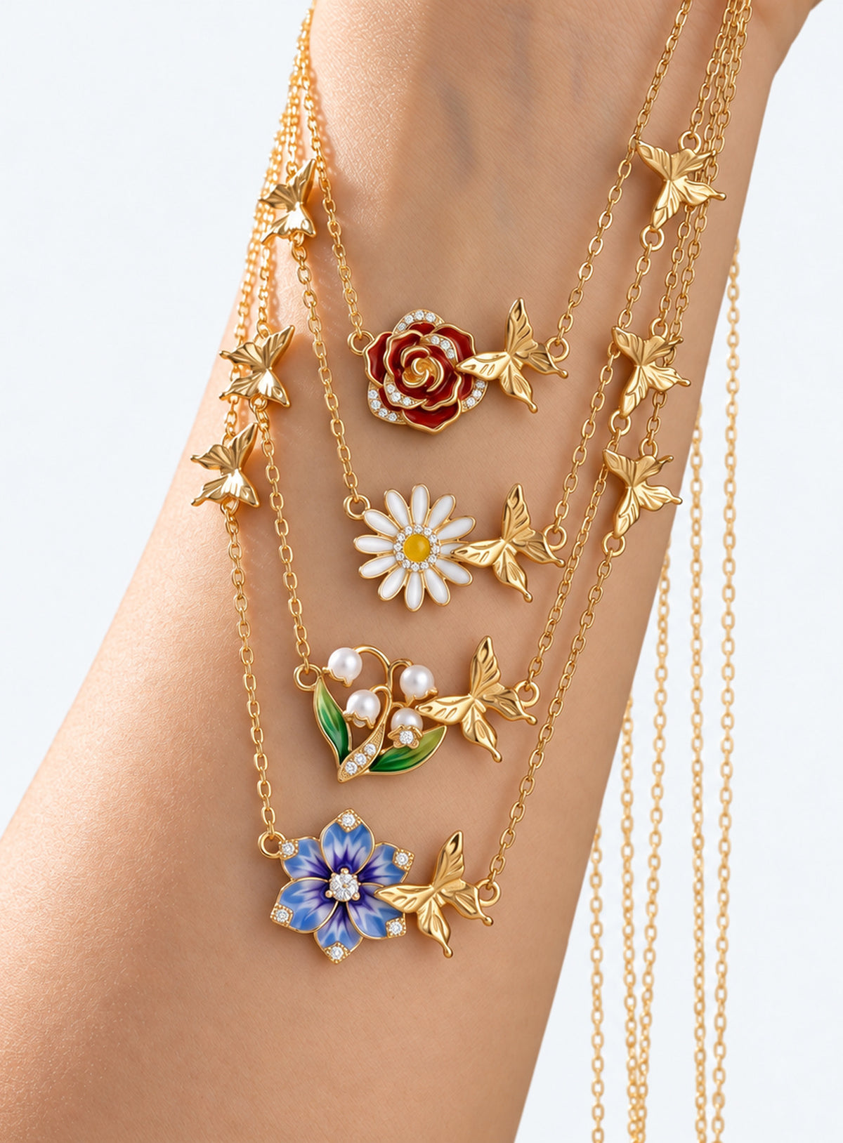 Birth flower necklace with an enamel flower centerpiece and small butterfly accents along the chain