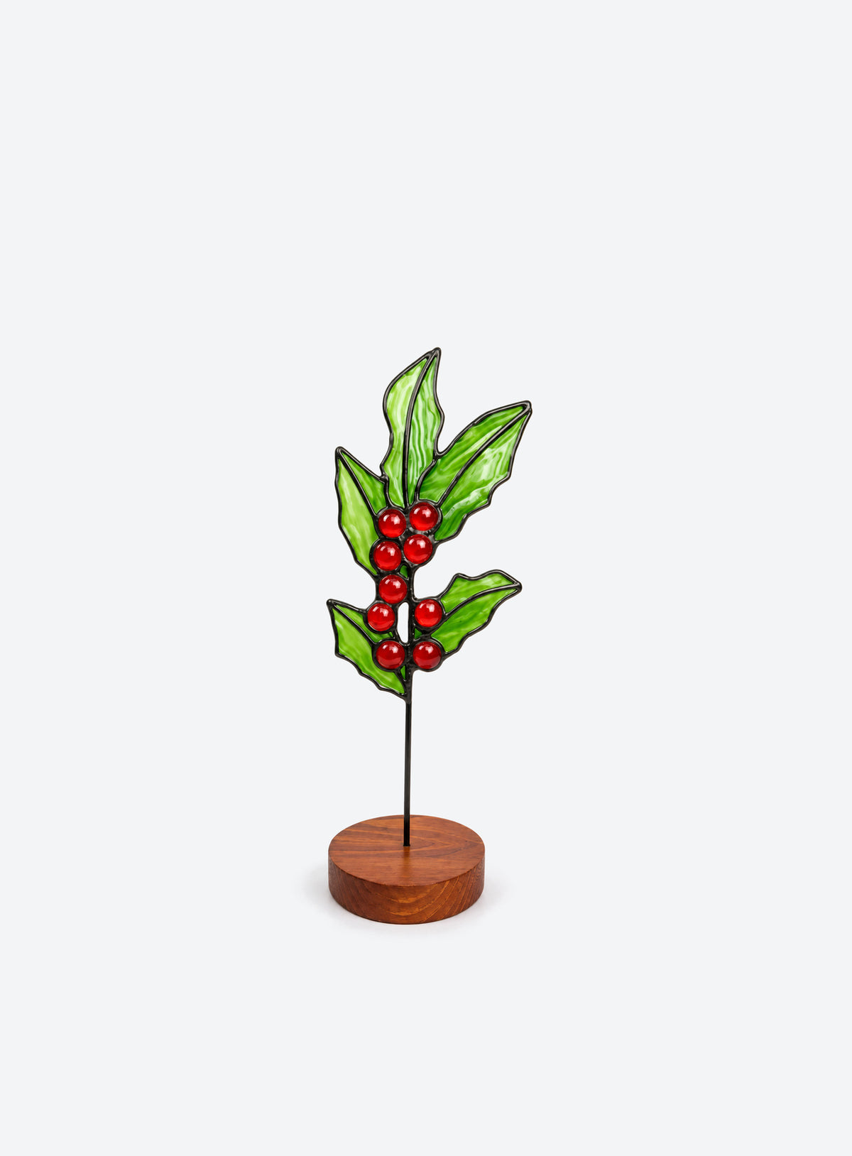 Freestanding colored-glass birth month flower with a round display base, photographed on a studio background. (December)