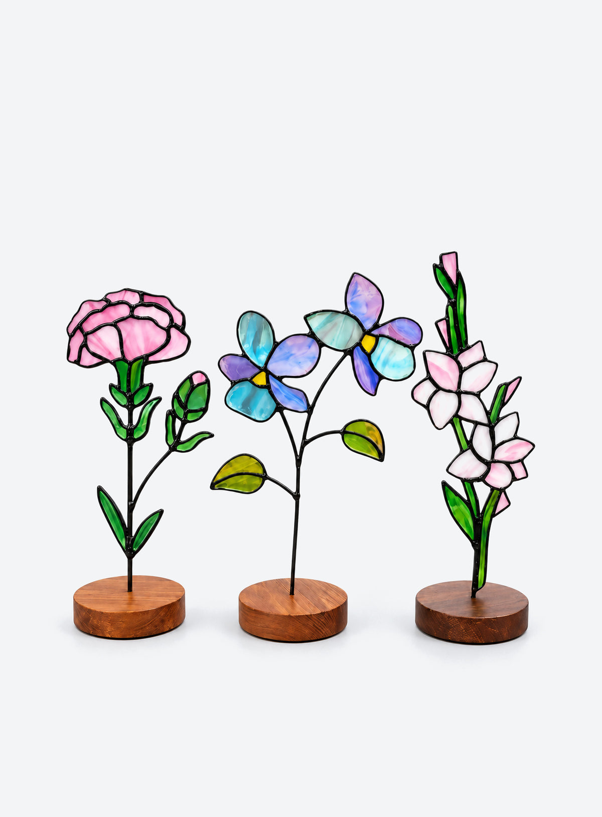 Freestanding colored-glass birth month flower with a round display base, photographed on a studio background.