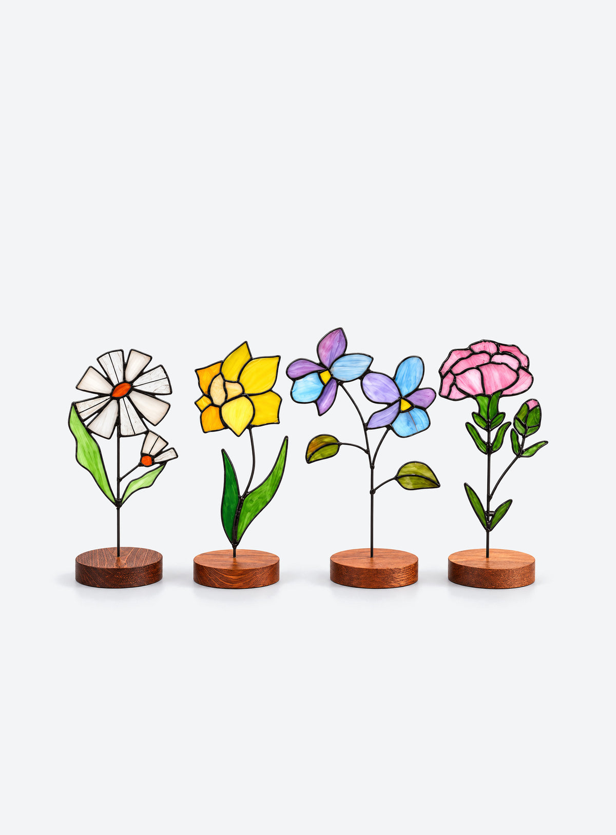 Freestanding colored-glass birth month flower with a round display base, photographed on a studio background.