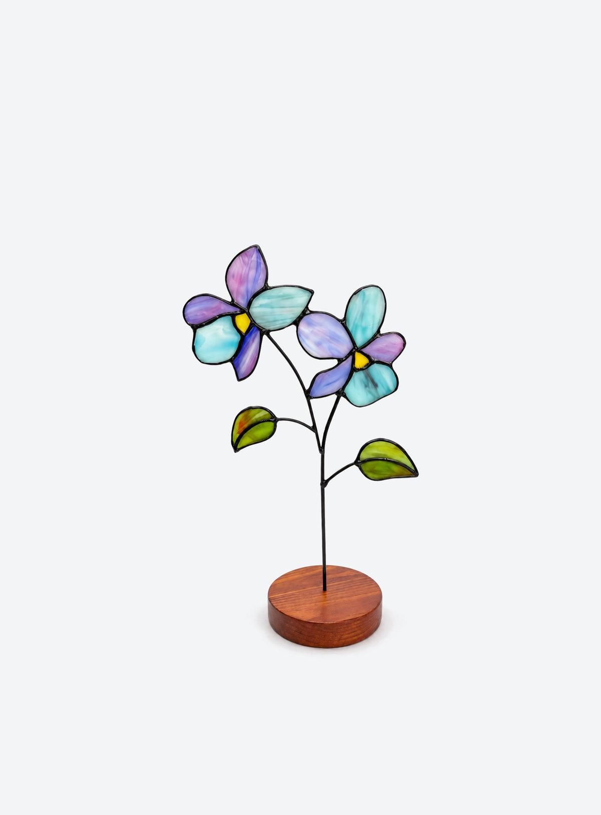 Freestanding colored-glass birth month flower with a round display base, photographed on a studio background. (February)