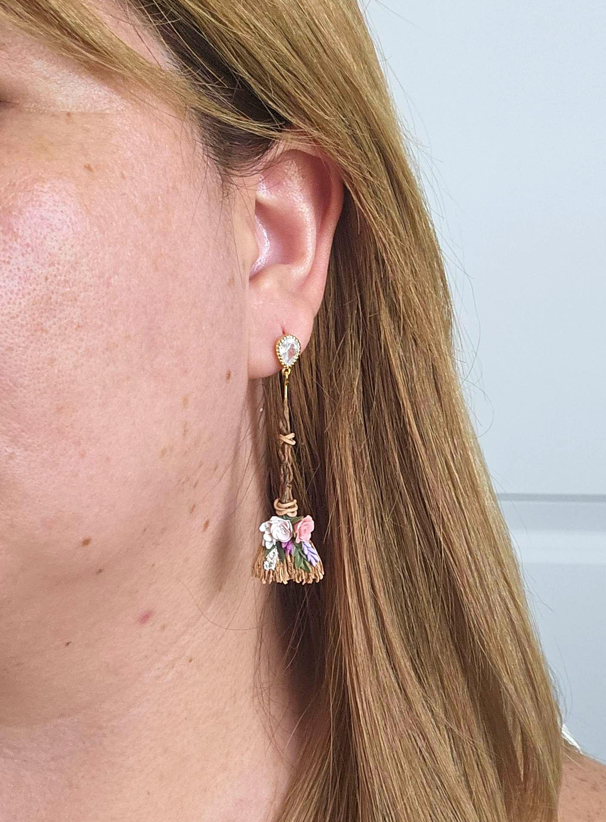 Black polymer clay witch broom earrings displayed in a studio photo