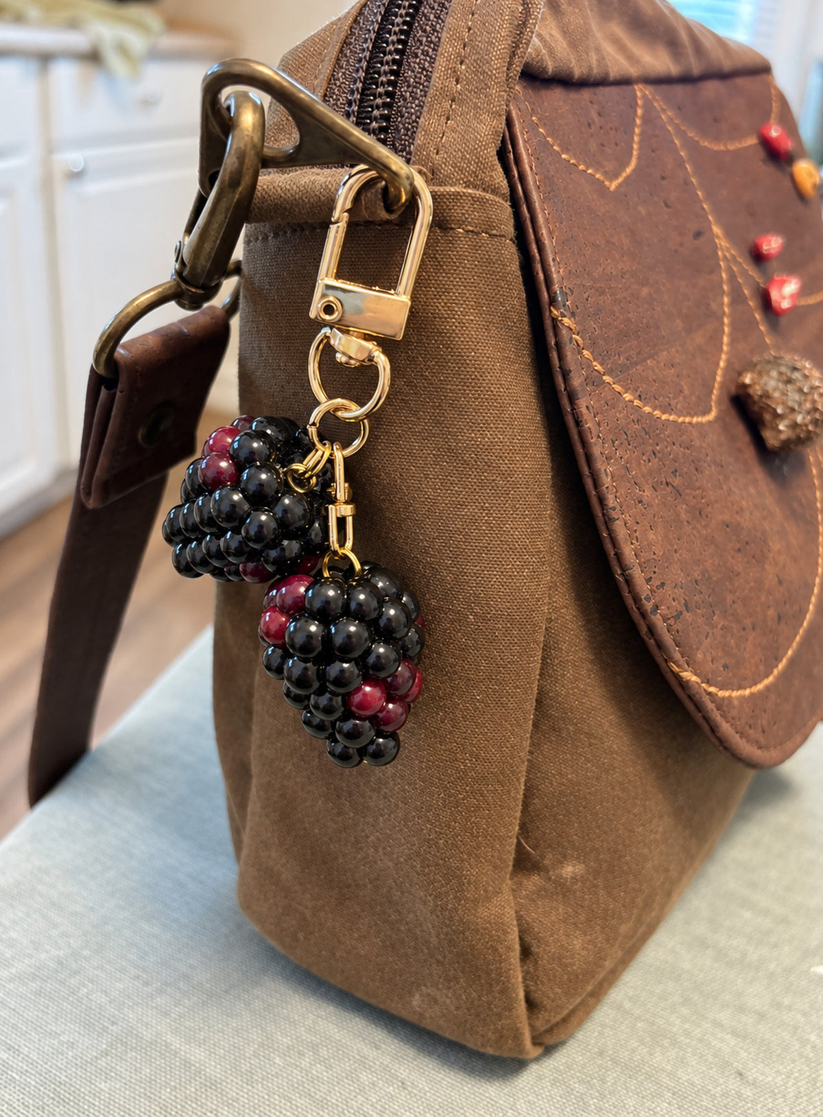 Blackberry bag charm with clustered black and burgundy details and gold-toned hardware