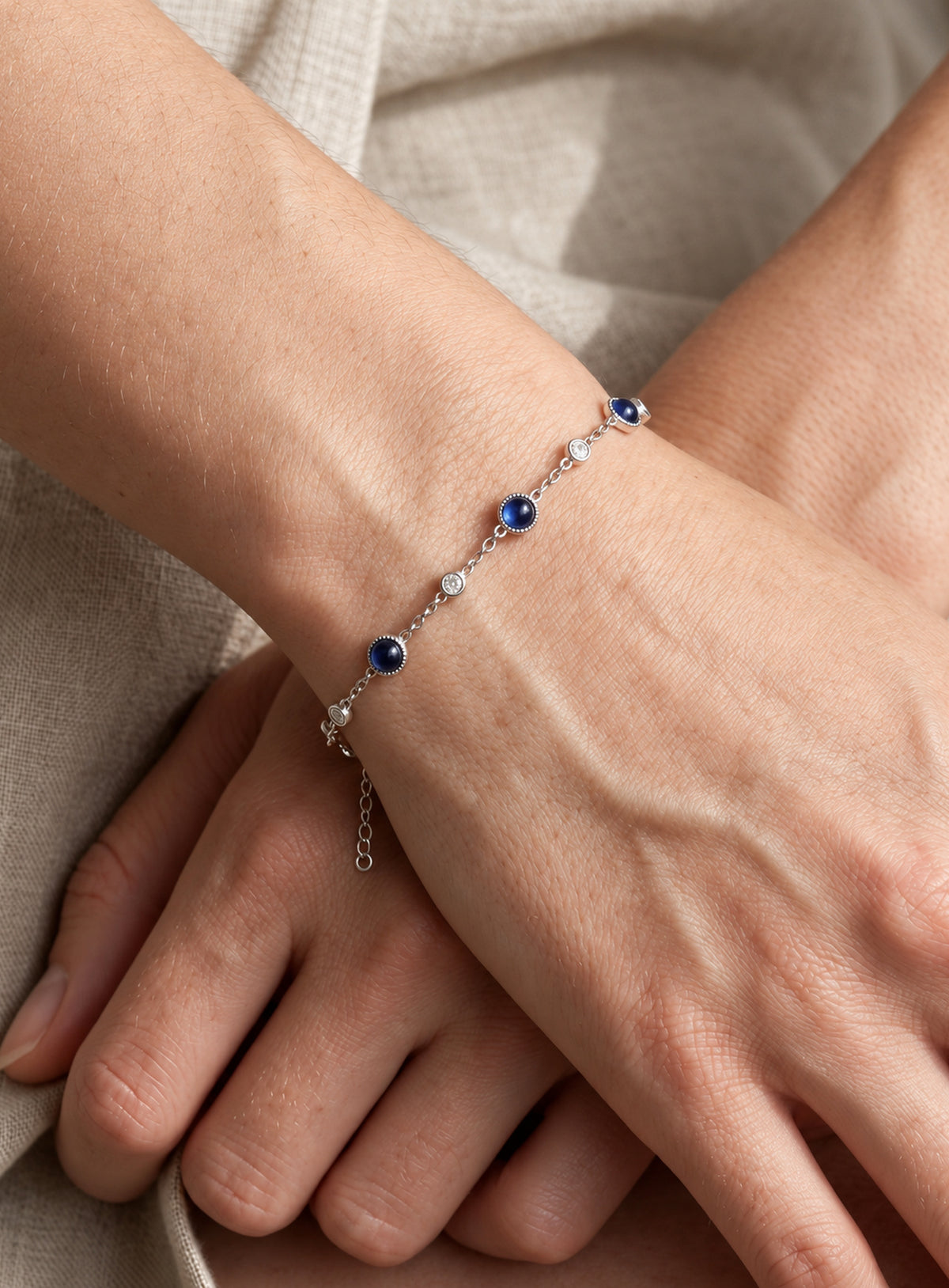 Blue and clear stone station bracelet with round settings and a delicate adjustable chain (Silver)