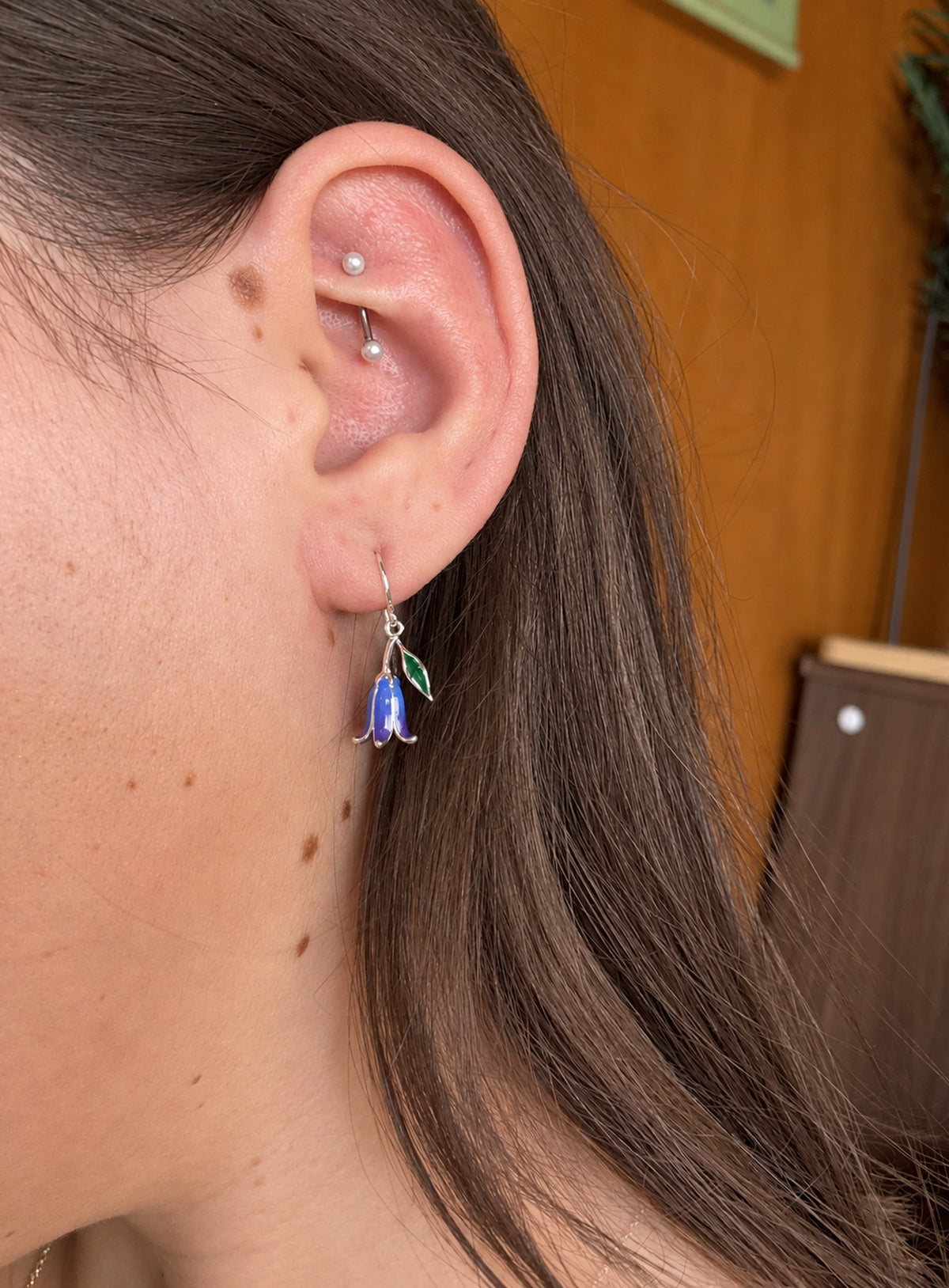 Blue and purple bell-shaped flower drop earrings with green leaves and silver-tone hooks