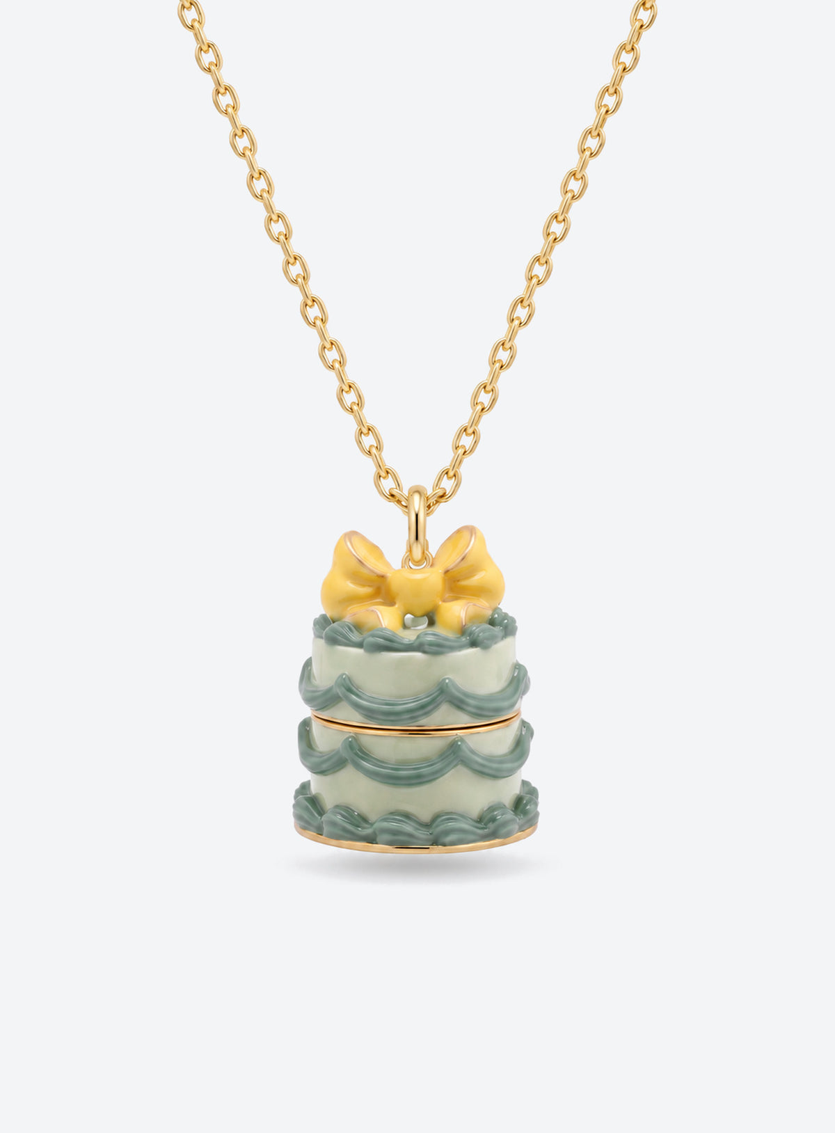 Cake-shaped necklace pendant with a bow, opening to reveal a small doll charm attached by a fine chain (Green Cake)