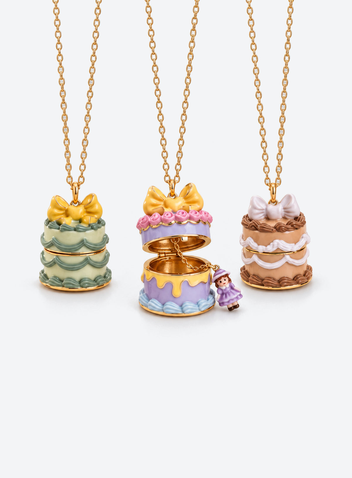 Cake-shaped necklace pendant with a bow, opening to reveal a small doll charm attached by a fine chain