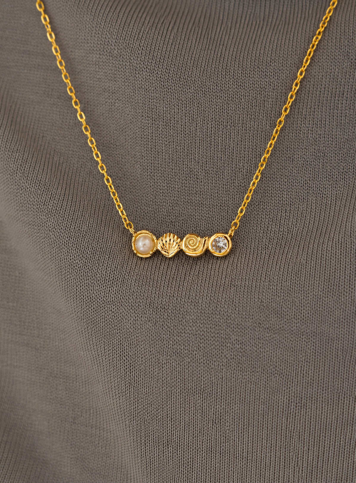 Delicate necklace with conch and scallop shell charms, a faux pearl and clear accents (Gold)