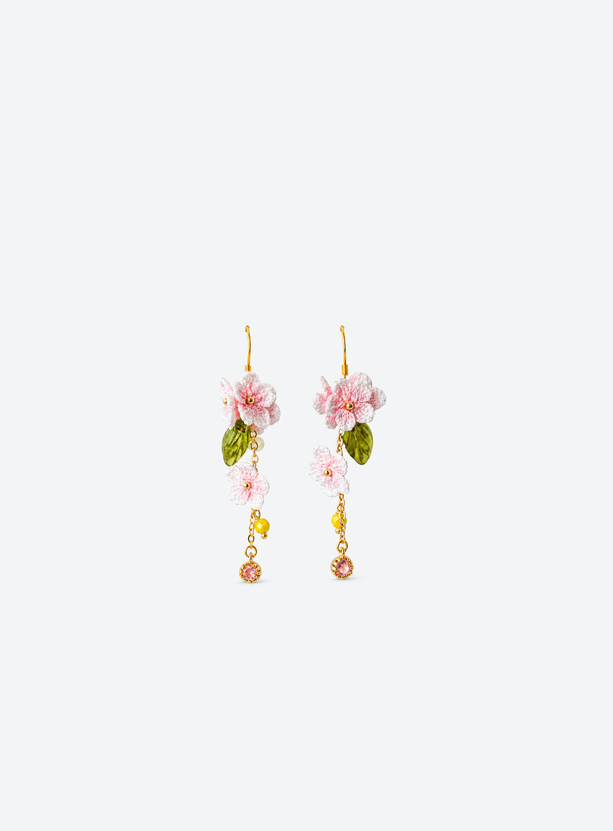 Pair of pink and white crochet cherry blossom earrings with green leaves and dangling bead accents