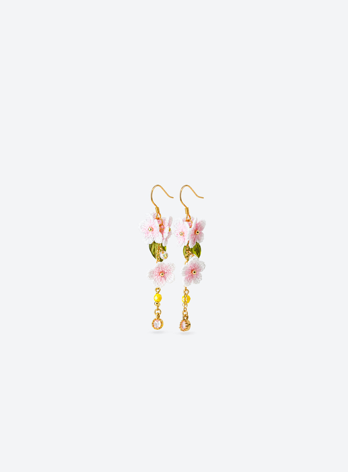 Pair of pink and white crochet cherry blossom earrings with green leaves and dangling bead accents