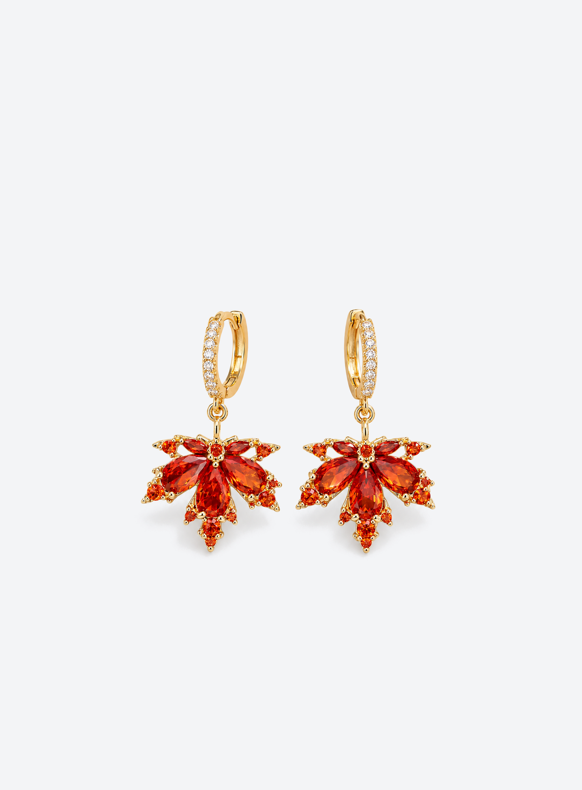 Gold tone earrings with red orange crystal maple leaf pendants