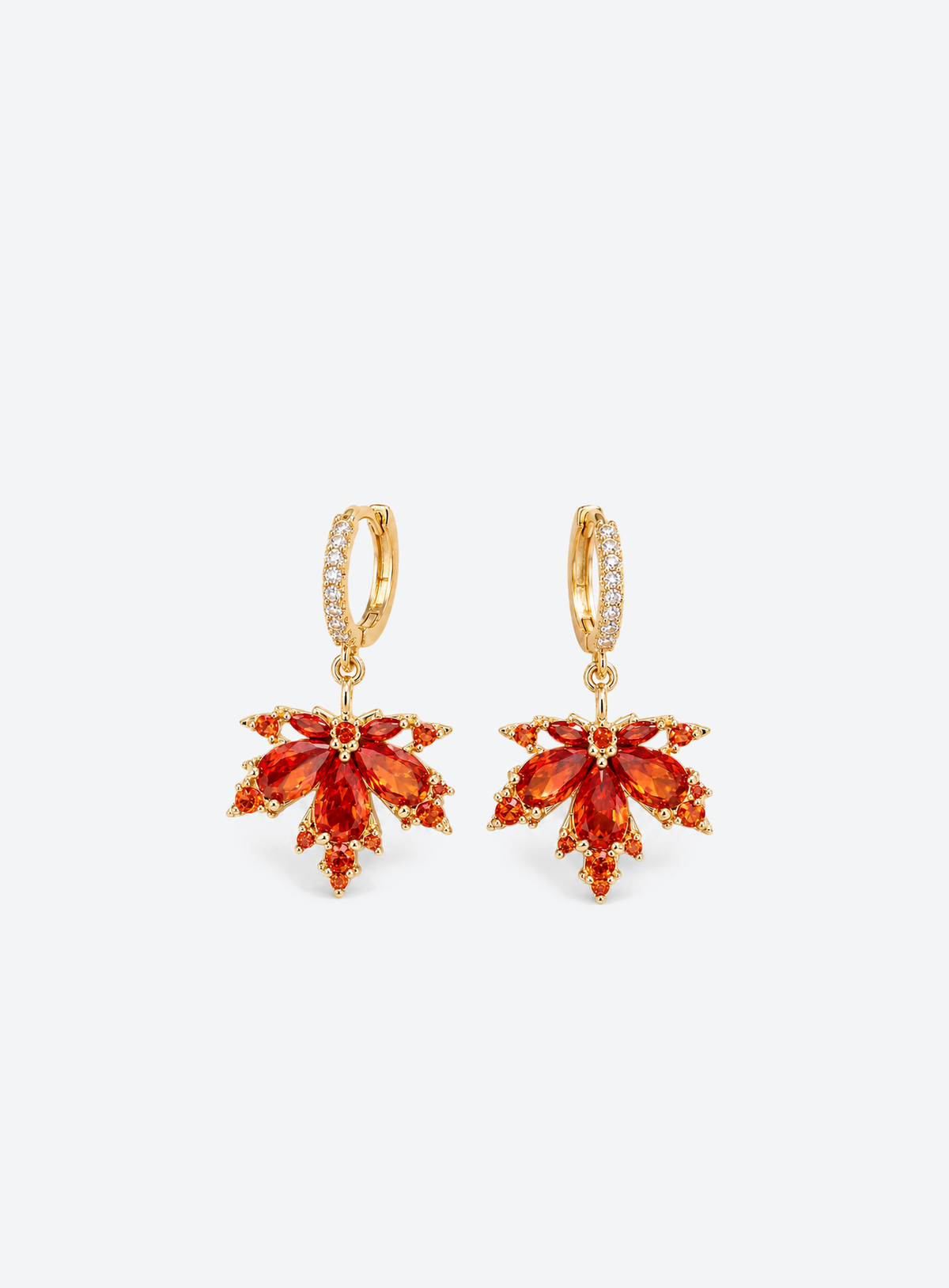 Gold tone earrings with red orange crystal maple leaf pendants