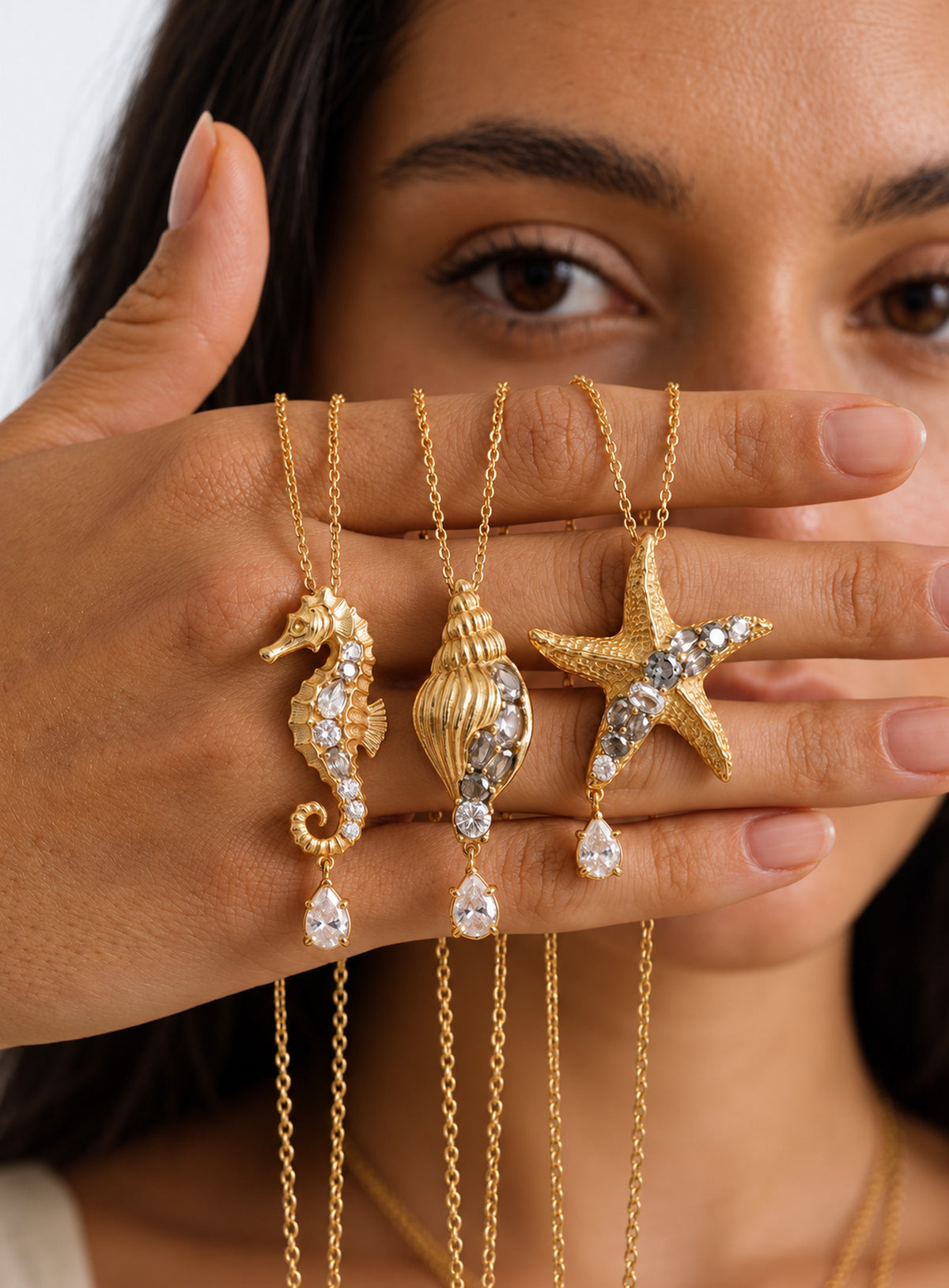 Ocean pendant necklace with a textured gold-tone surface, clear crystal accents and a hanging teardrop crystal