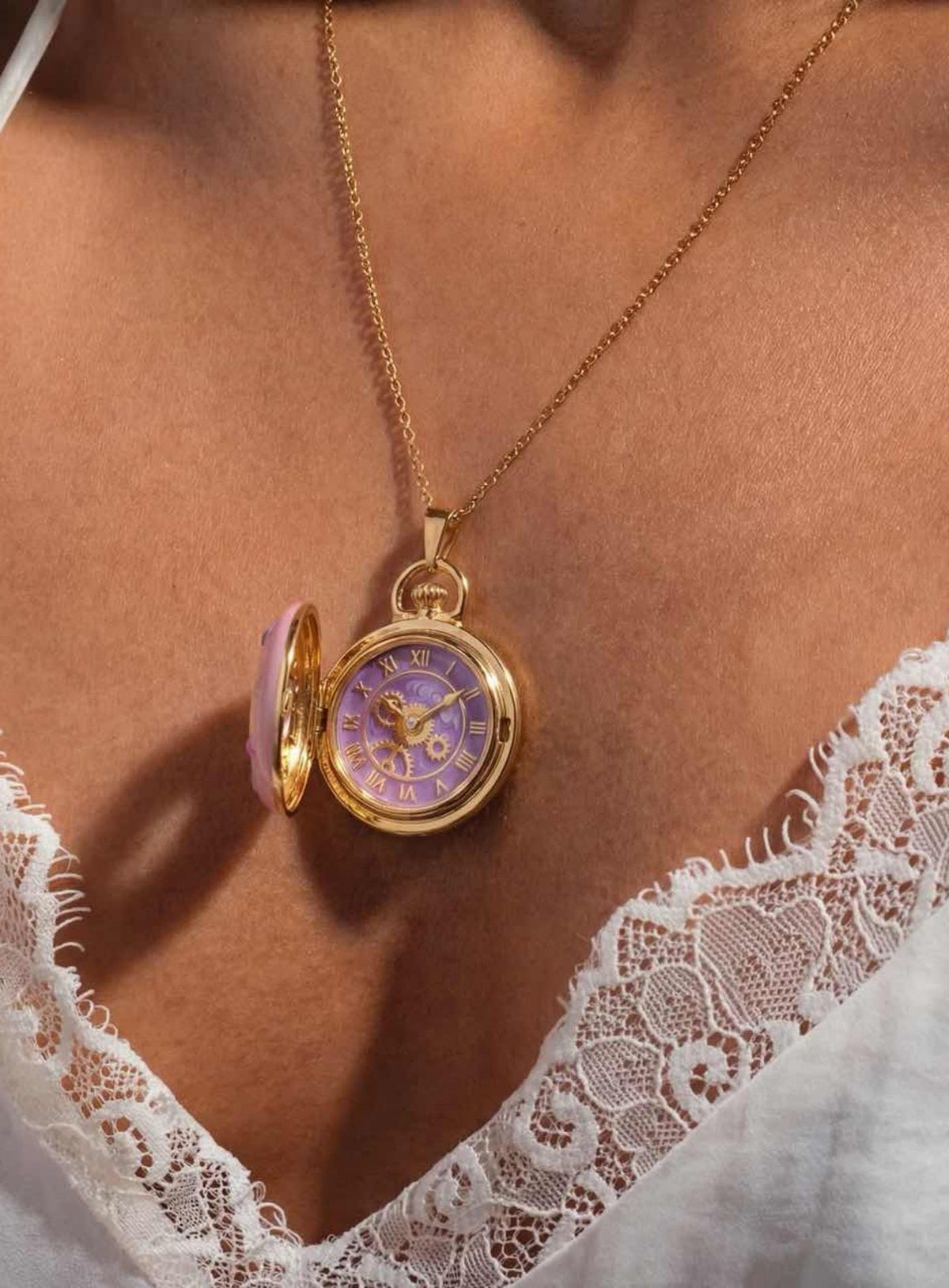 Round locket necklace with a pink enamel cover, purple clock motifs and small colored accents (Gold)