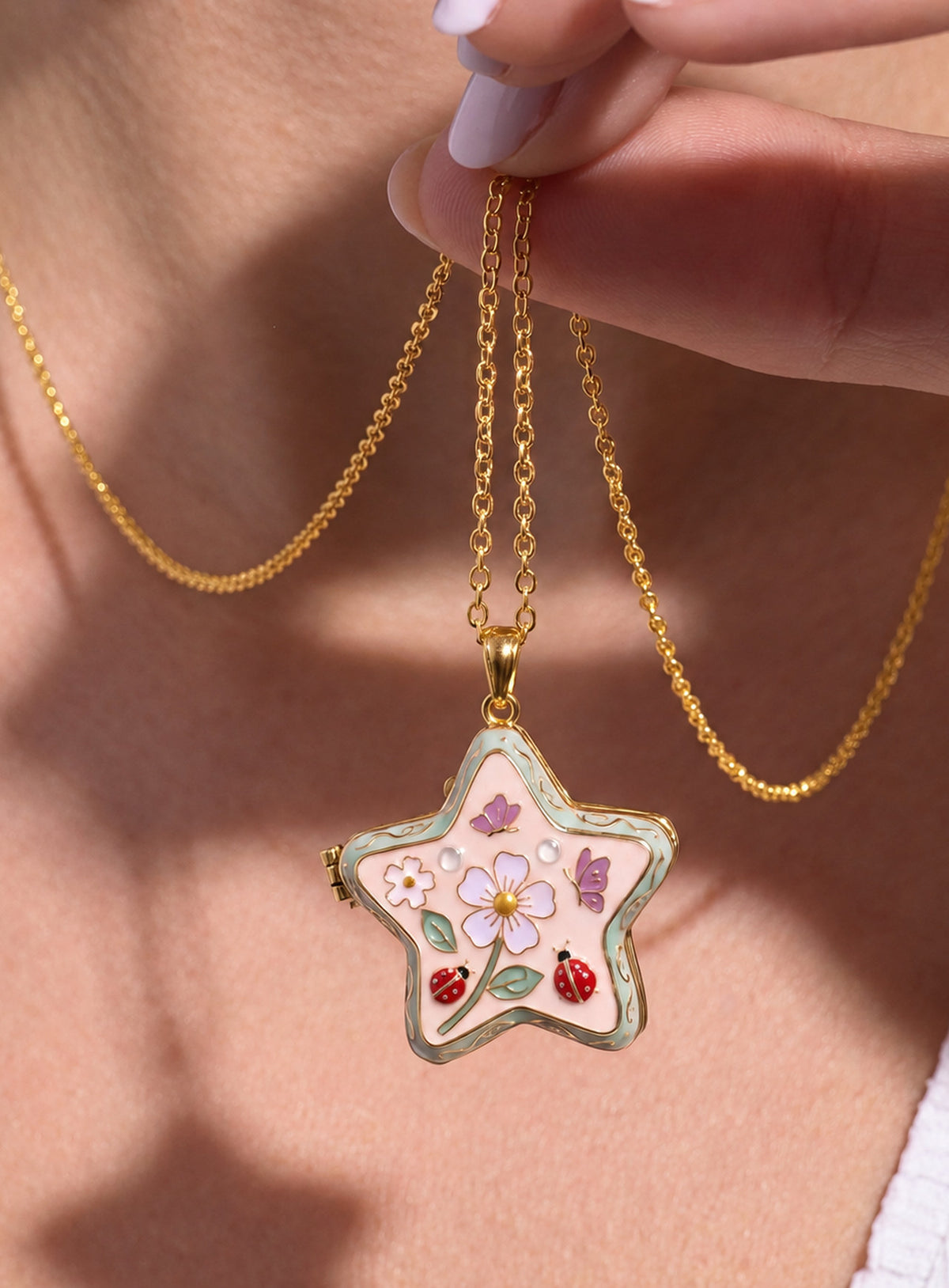 Star-shaped enamel locket necklace with colorful decorative details on a gold-tone chain (Ladybug)