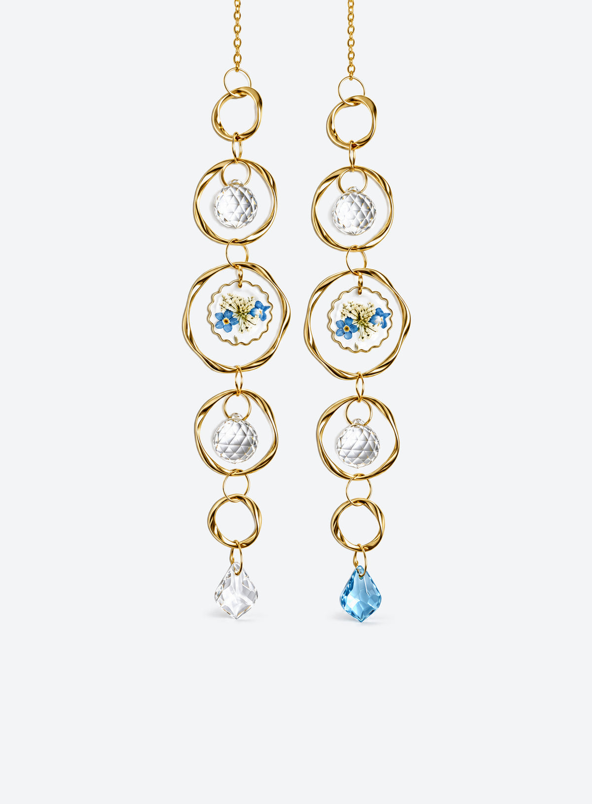 Hanging suncatcher with gold-colored rings, clear faceted balls, a blue-and-white flower detail, and a teardrop pendant.
