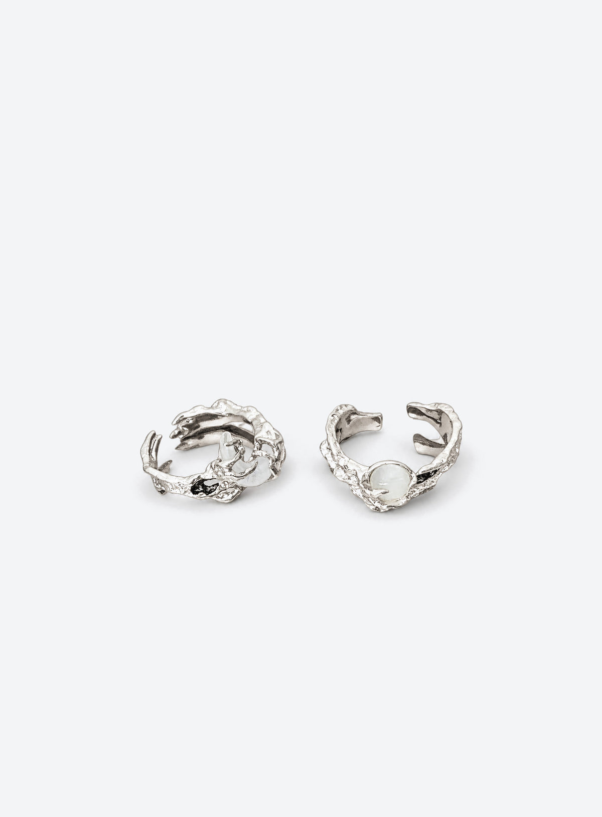 Two silver-tone open-band rings with textured branch-like bands, a round white moon, and a white crescent