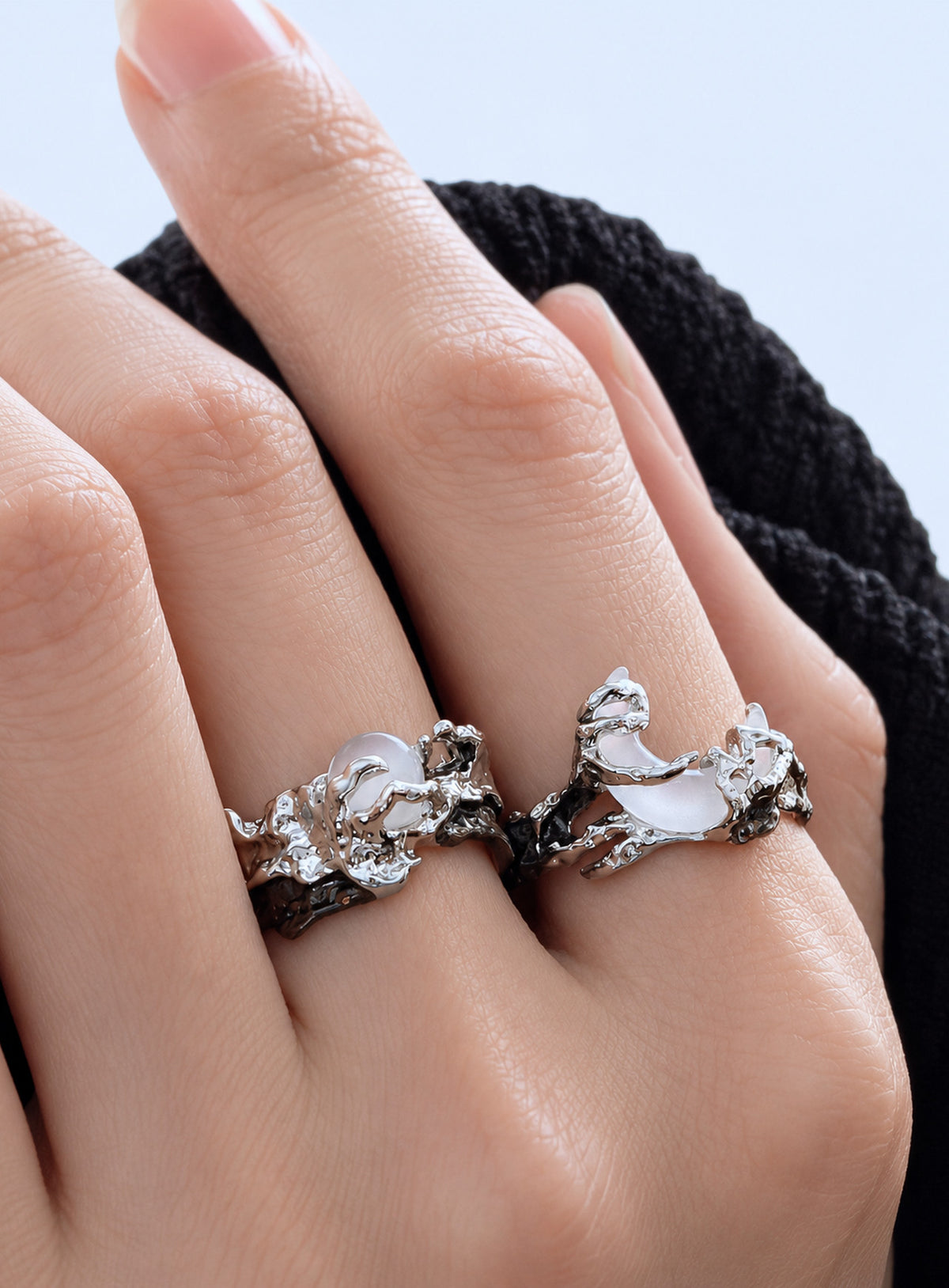 Two silver-tone open-band rings with textured branch-like bands, a round white moon, and a white crescent
