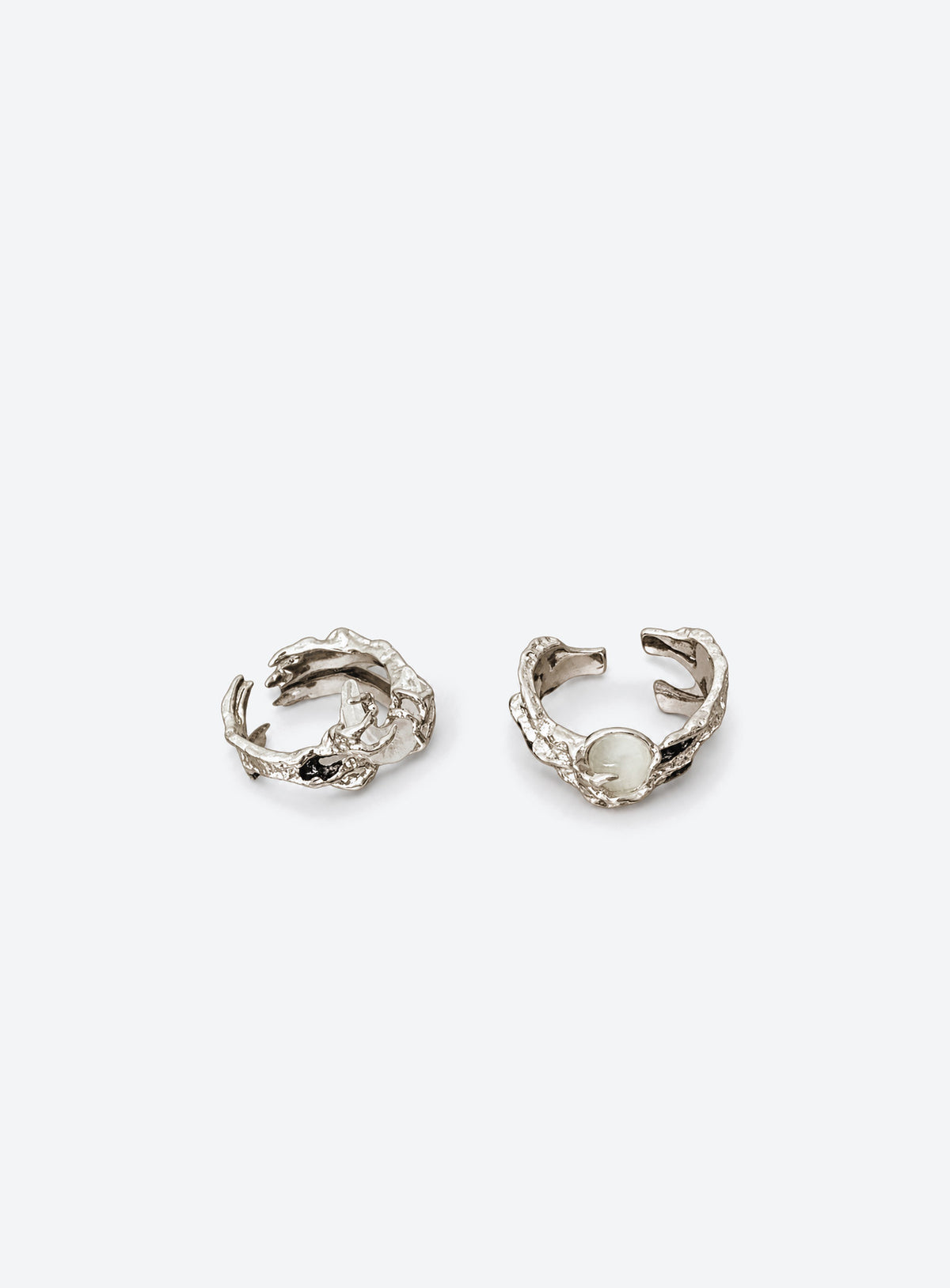 Two silver-tone open-band rings with textured branch-like bands, a round white moon, and a white crescent