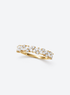 Gold-tone ring with mixed-shape clear cubic zirconia stones across the front and a slender plain band at the back