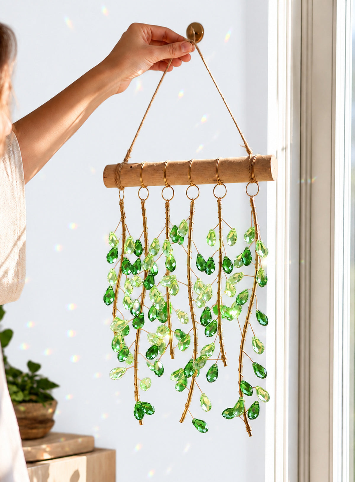 Green leaf suncatcher with six strands of faceted leaves, gold-tone wire, a horizontal bar, and rope hanger.