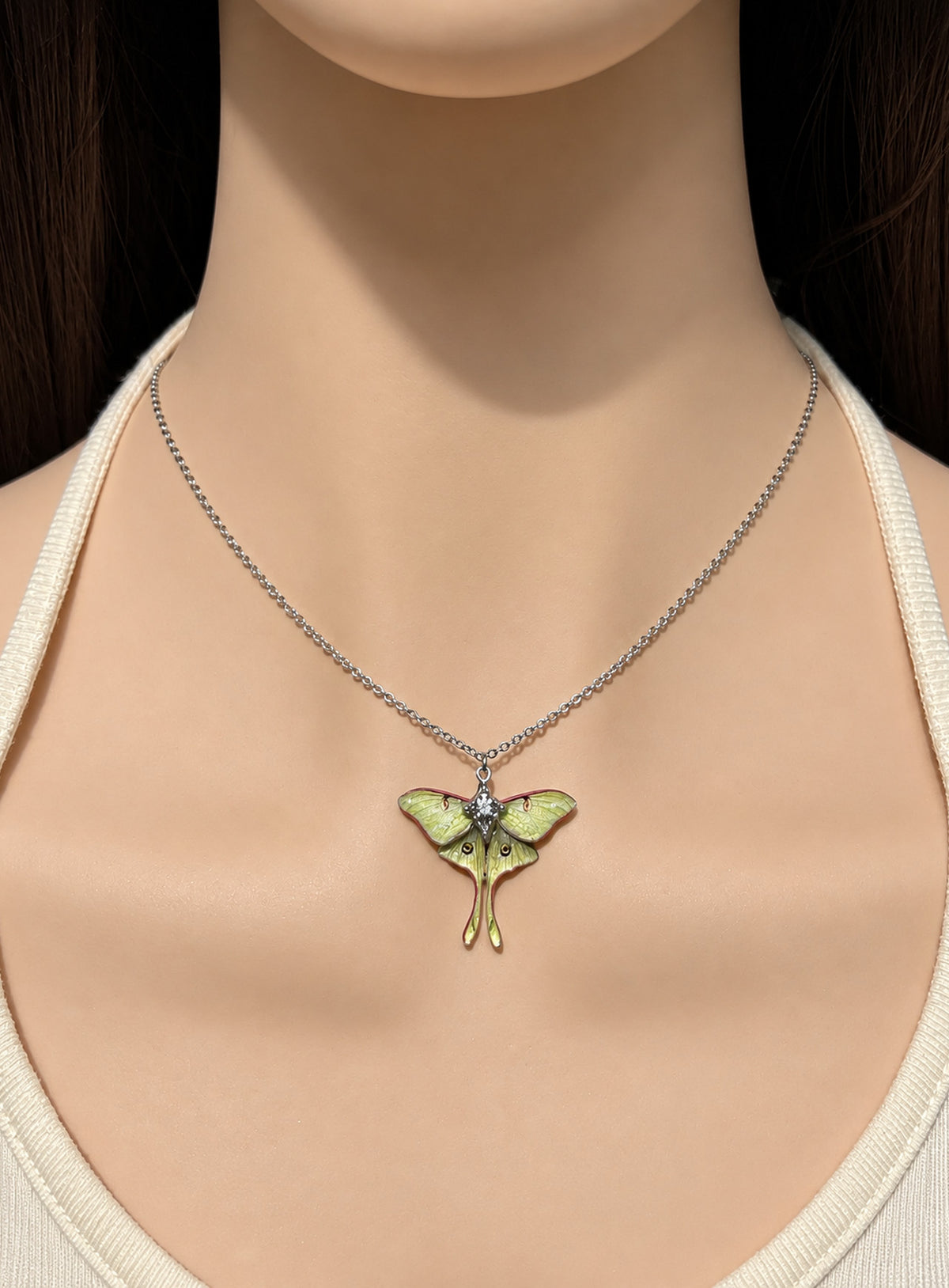 Pearlescent green luna moth pendant with painted wing details, two long tails, and clear body rhinestones