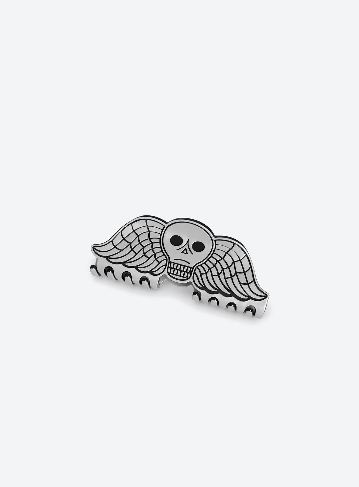 Small grey acetate hair claw with a winged skull design and dark outlines
