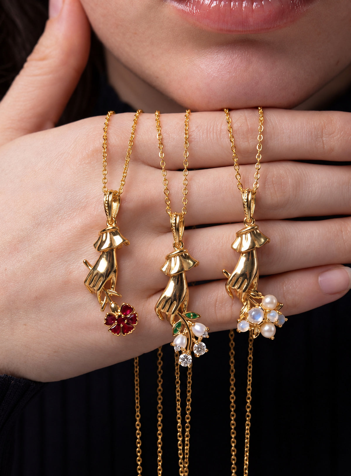 Necklace with a sculpted hand pendant holding a floral bouquet with crystal accents