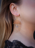 Gold-plated brass spider web earrings with Herkimer diamond charms on a studio background