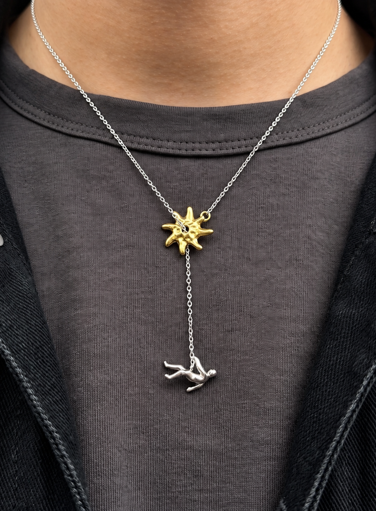 Y-shaped necklace with a hammered sunburst above a small falling figure