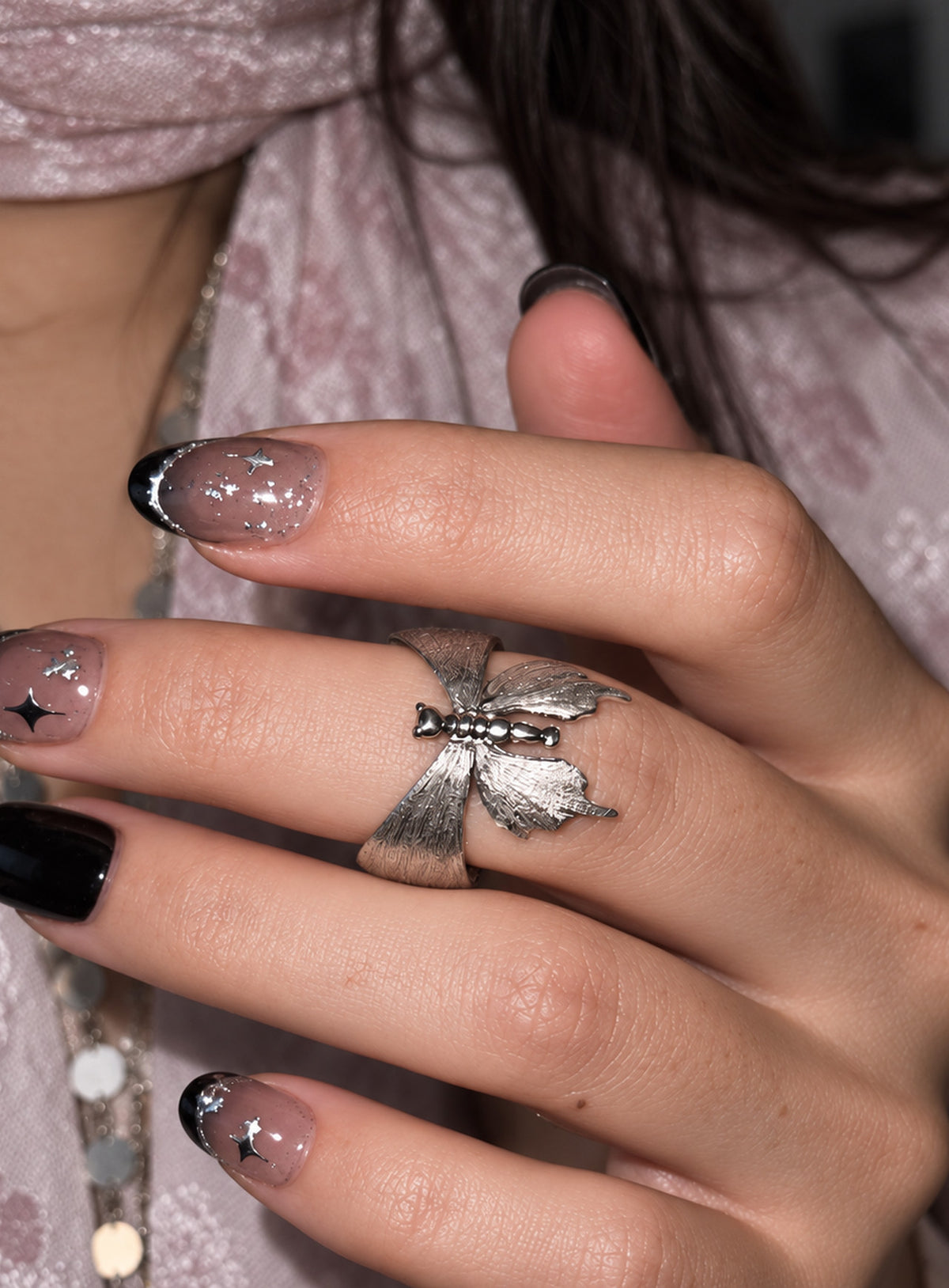 A silver-tone luna moth ring with brushed wings, polished tail details and an open wraparound band