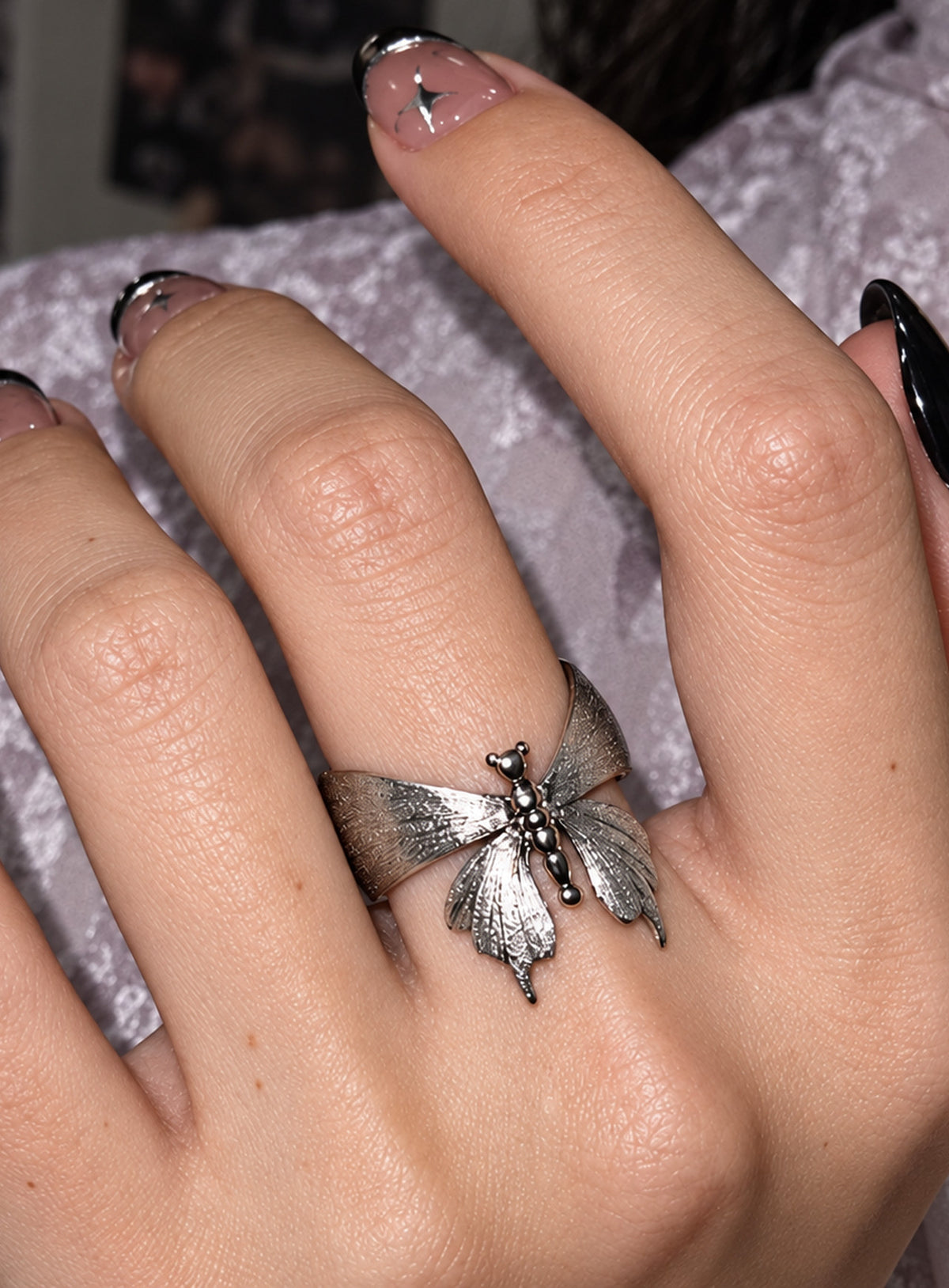 A silver-tone luna moth ring with brushed wings, polished tail details and an open wraparound band