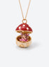 An open mushroom house pendant necklace with a miniature figure beneath its spotted enamel cap