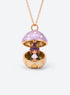 An open mushroom house pendant necklace with a miniature figure beneath its spotted enamel cap