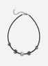 Black beaded necklace with four outward-facing shell crescents around a round center disc and a silver-finish clasp. (Silver)
