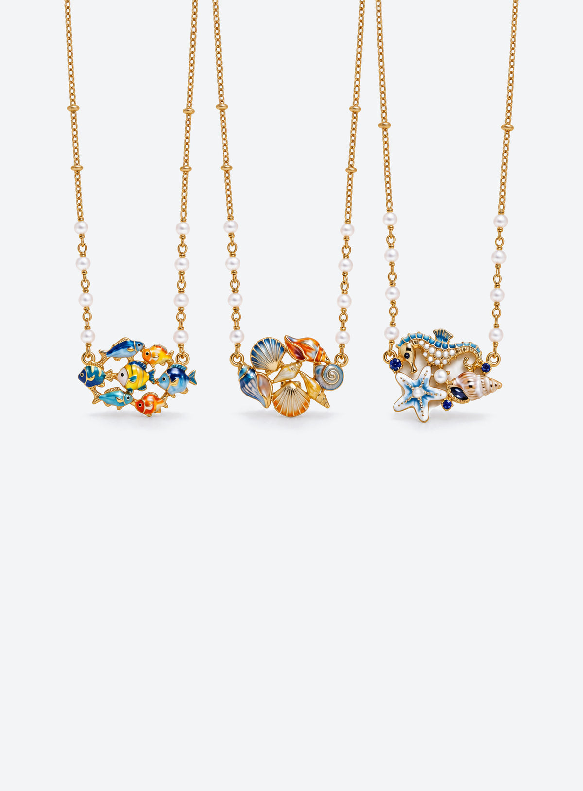 Ocean-themed necklace with a pearl station chain and a cluster of shells, sea creatures, or colorful fish