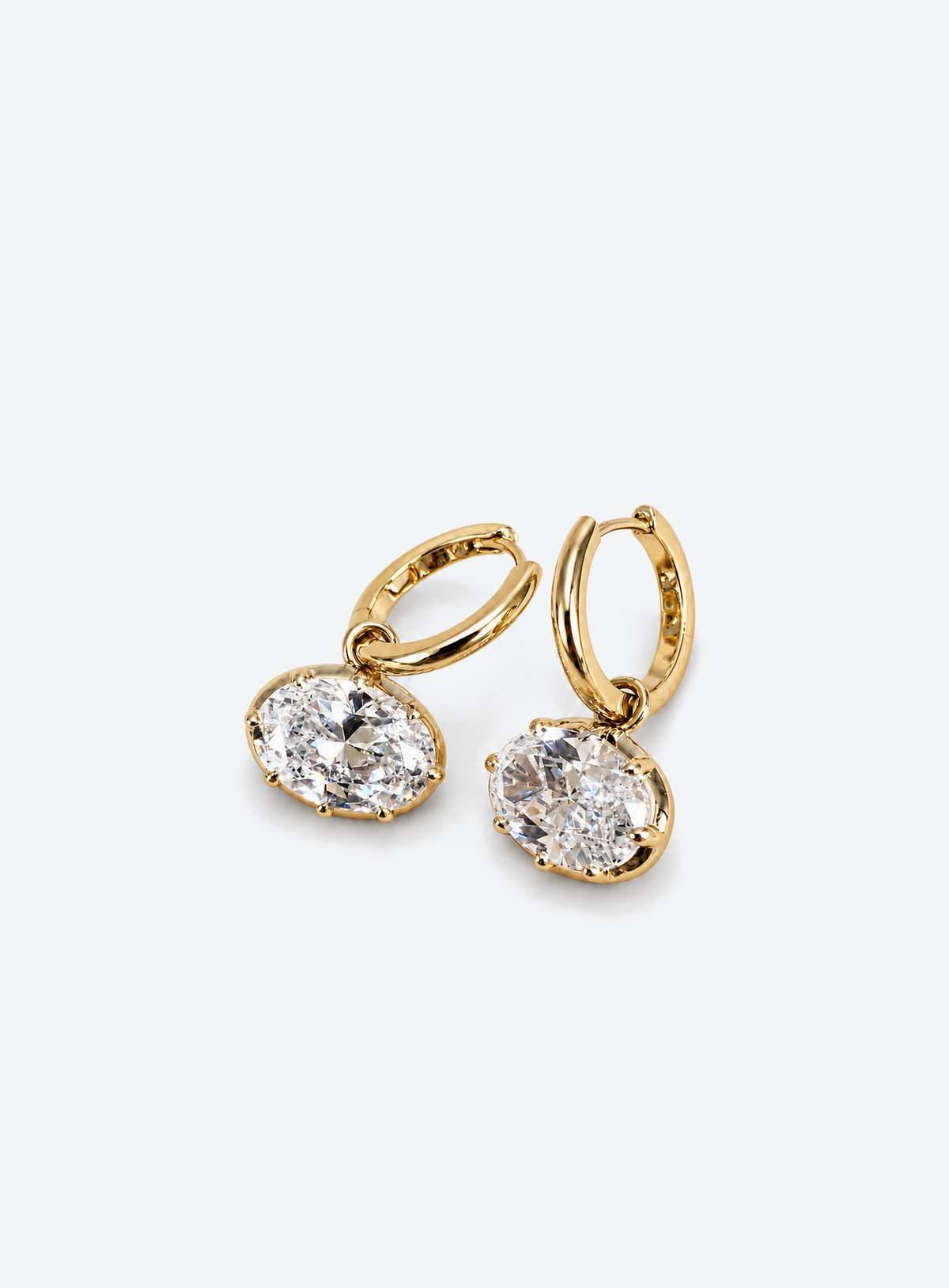 Gold-tone huggie earrings with suspended clear oval cubic zirconia drops