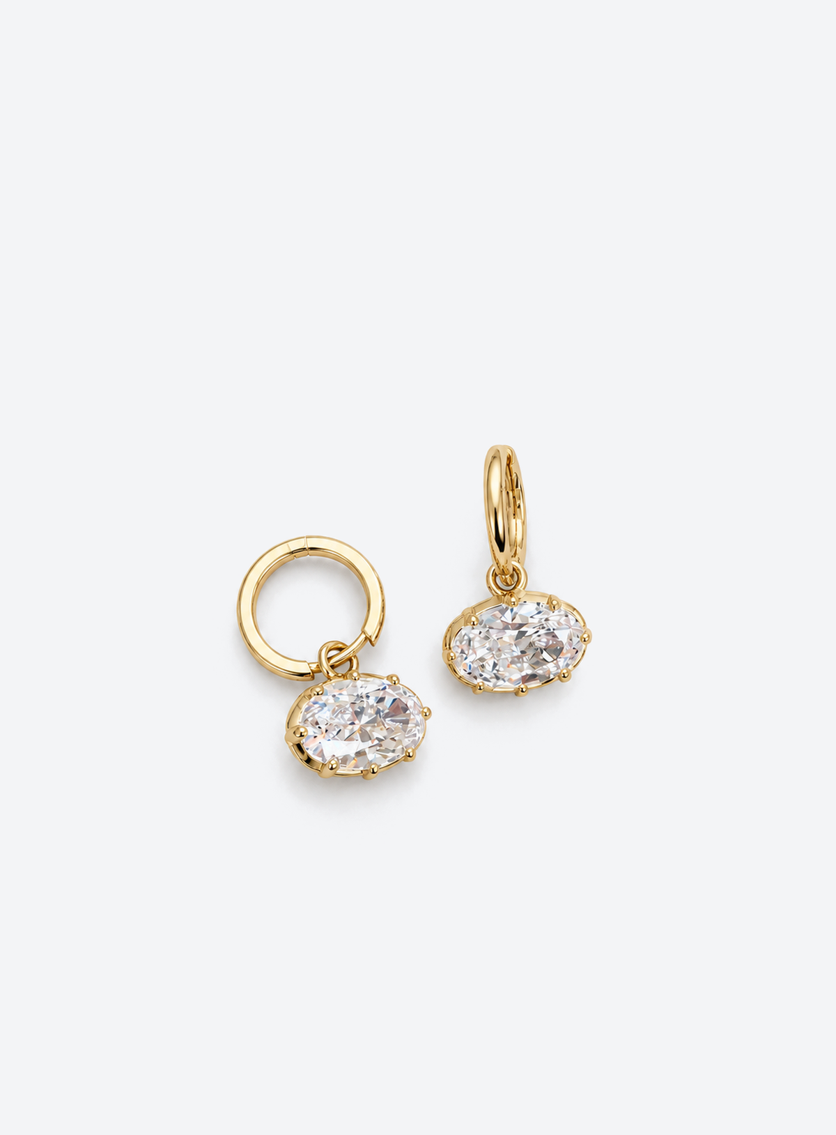 Gold-tone huggie earrings with suspended clear oval cubic zirconia drops
