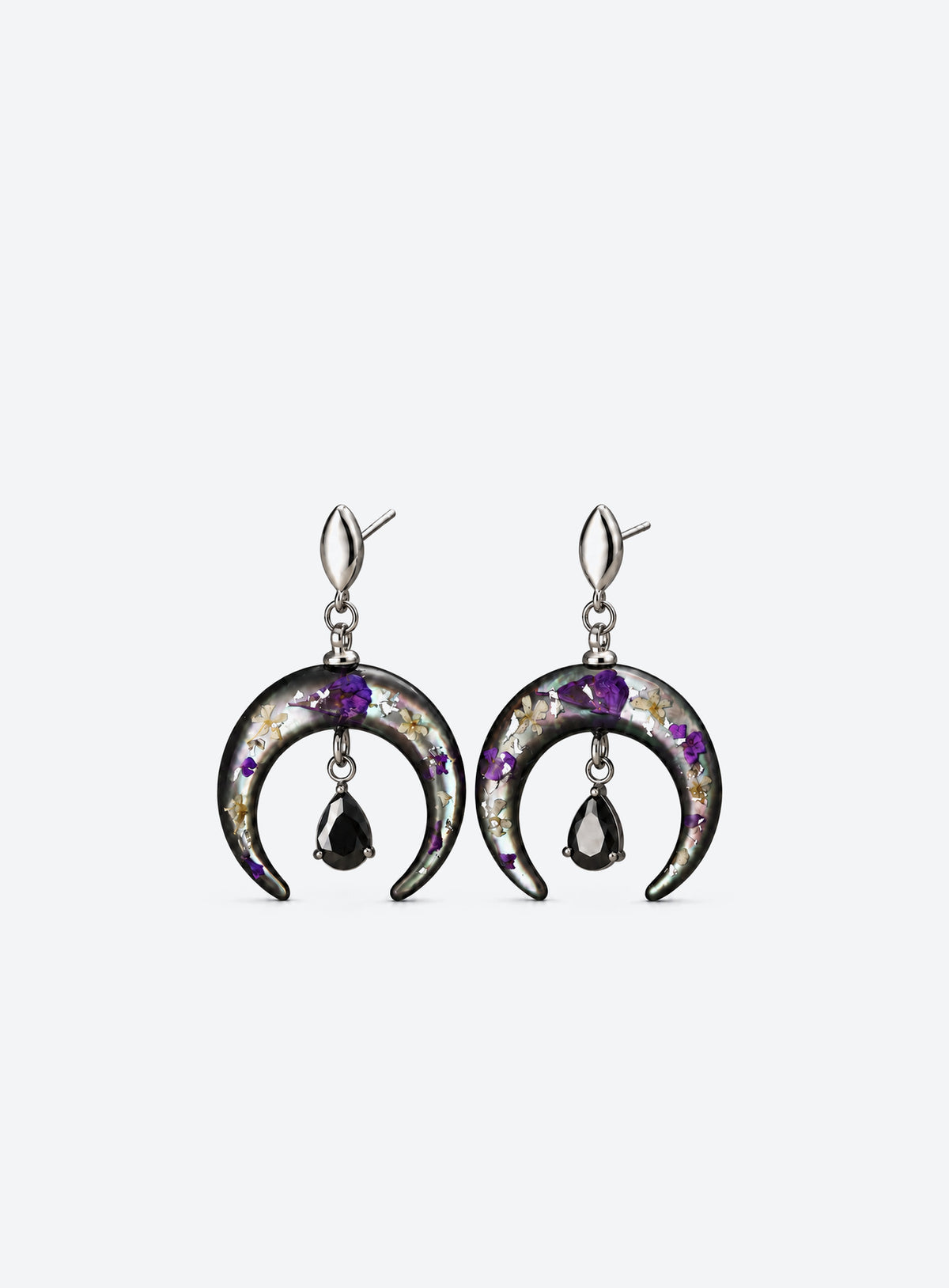 Pair of silver-finish earrings with purple flowers on dark crescents and hanging black teardrop stones.