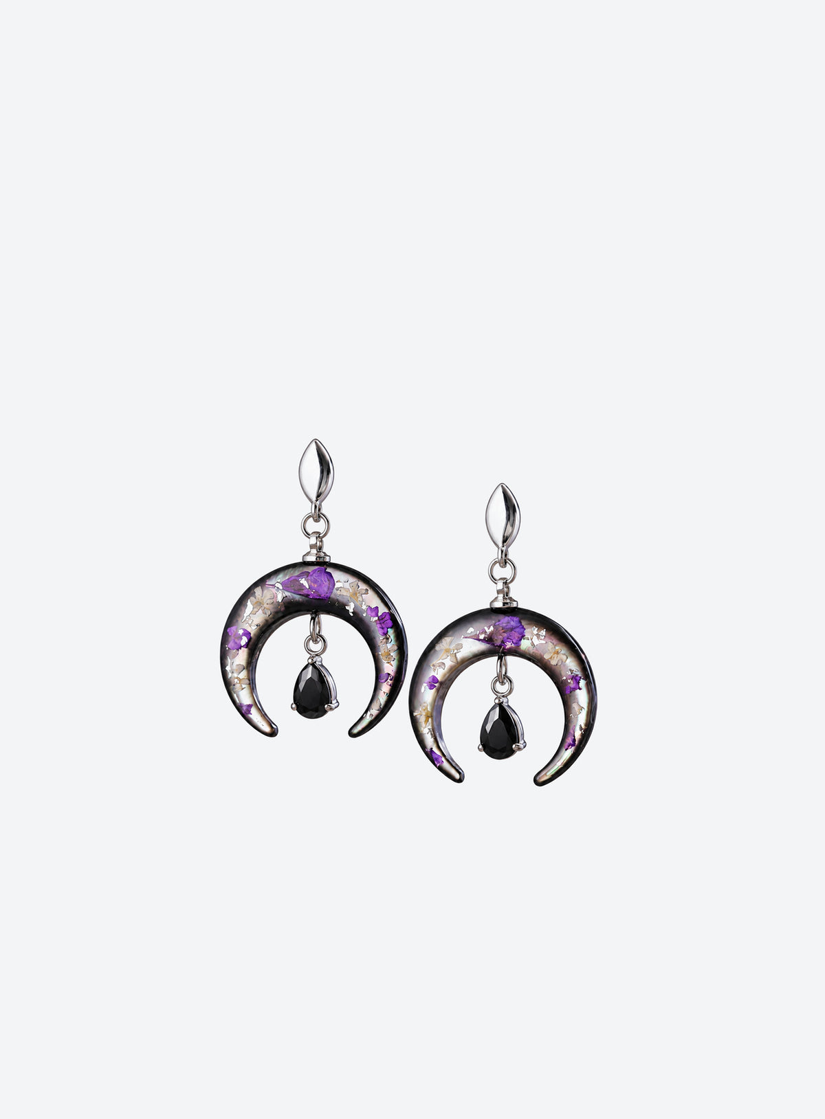 Pair of silver-finish earrings with purple flowers on dark crescents and hanging black teardrop stones.