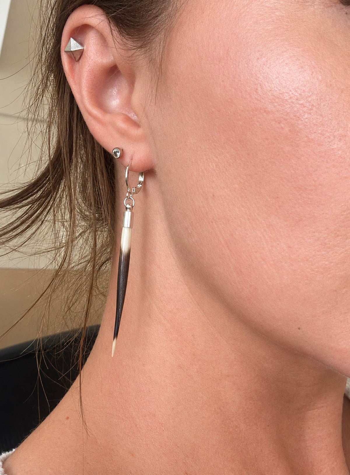 Long quill-shaped drop earrings with pale tops, dark tips, and ear wires