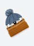 Bright blue pom-pom beanie with ochre ribbed cuff and black-and-white sheep motifs