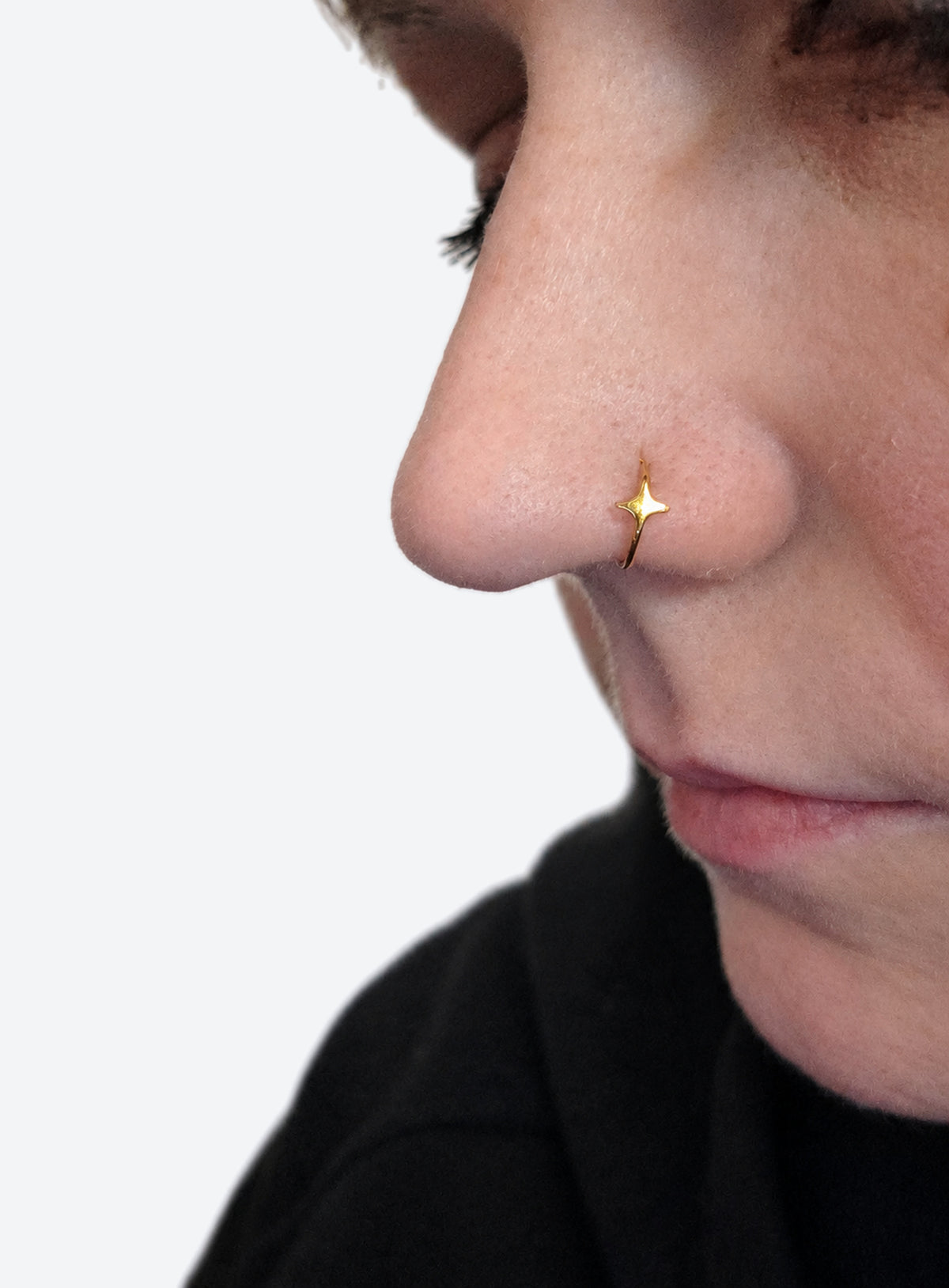 Star detail nose hoop with hinged clicker closure, shown in a studio product photo (Gold)